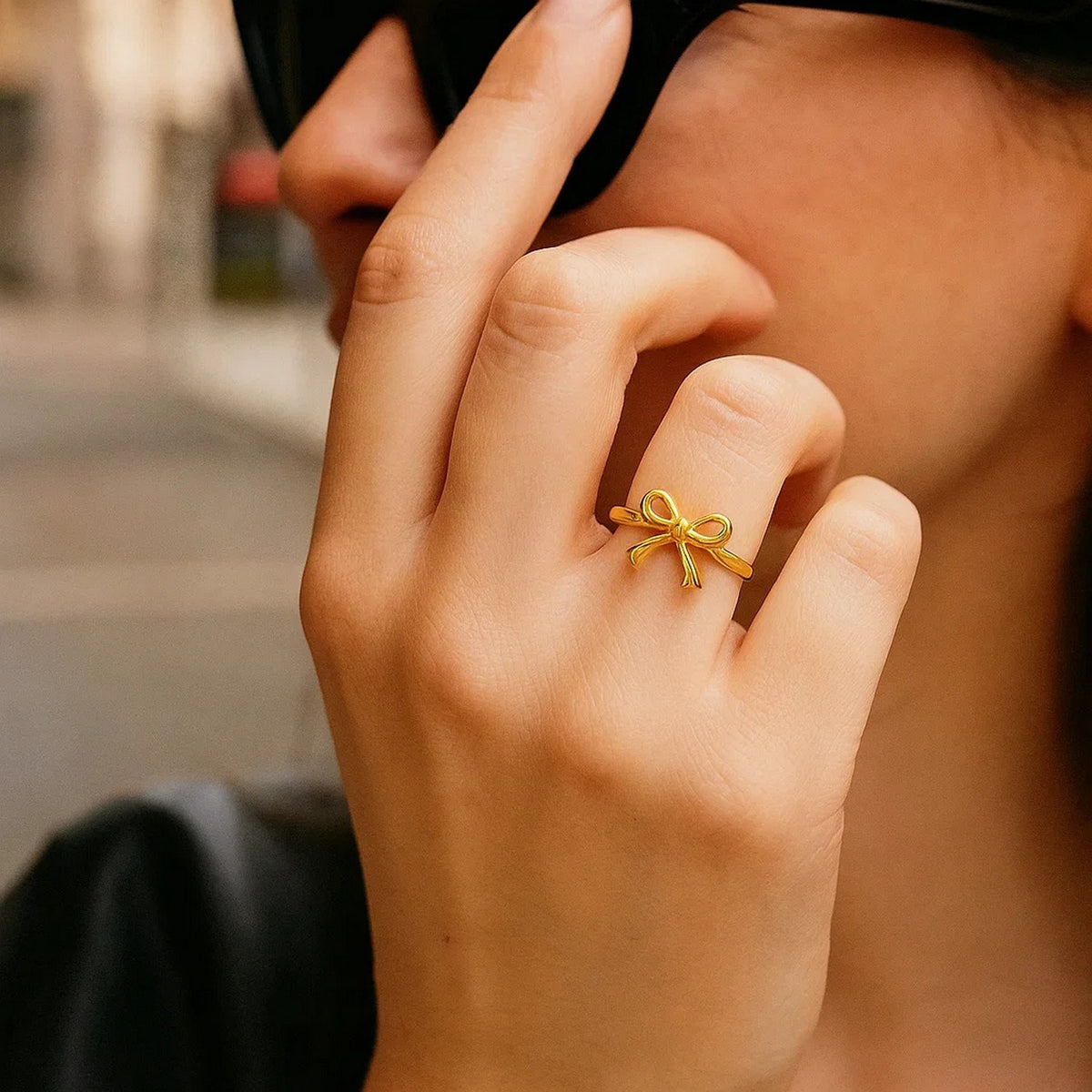 14K yellow gold bow ring worn on finger, lifestyle shot showing delicate bow design 36866