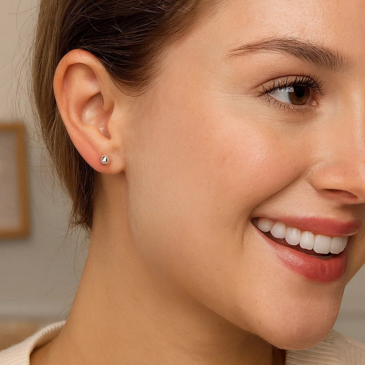 Woman smiling wearing sterling silver 5mm ball stud earring close up view