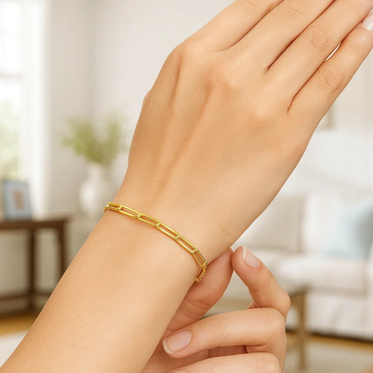 10K yellow gold paperclip chain bracelet on raised wrist, lifestyle shot showing fine gold link bracelet for her