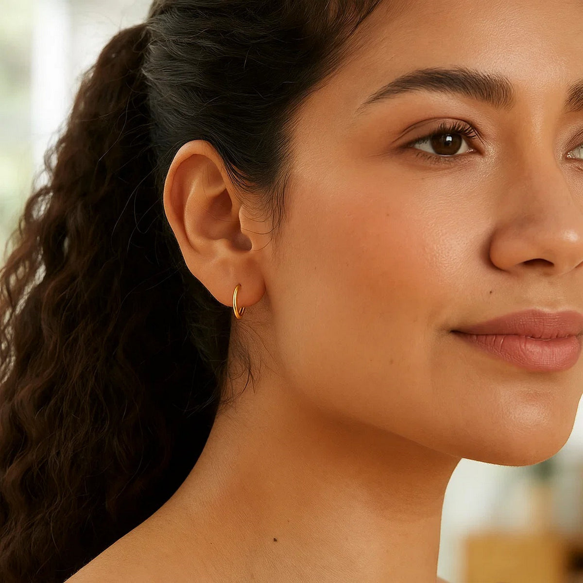 Woman wearing Savannah Lane Jewelry 10K yellow gold mini endless hoop earrings, close-up lifestyle view – small gold hoops for everyday wear