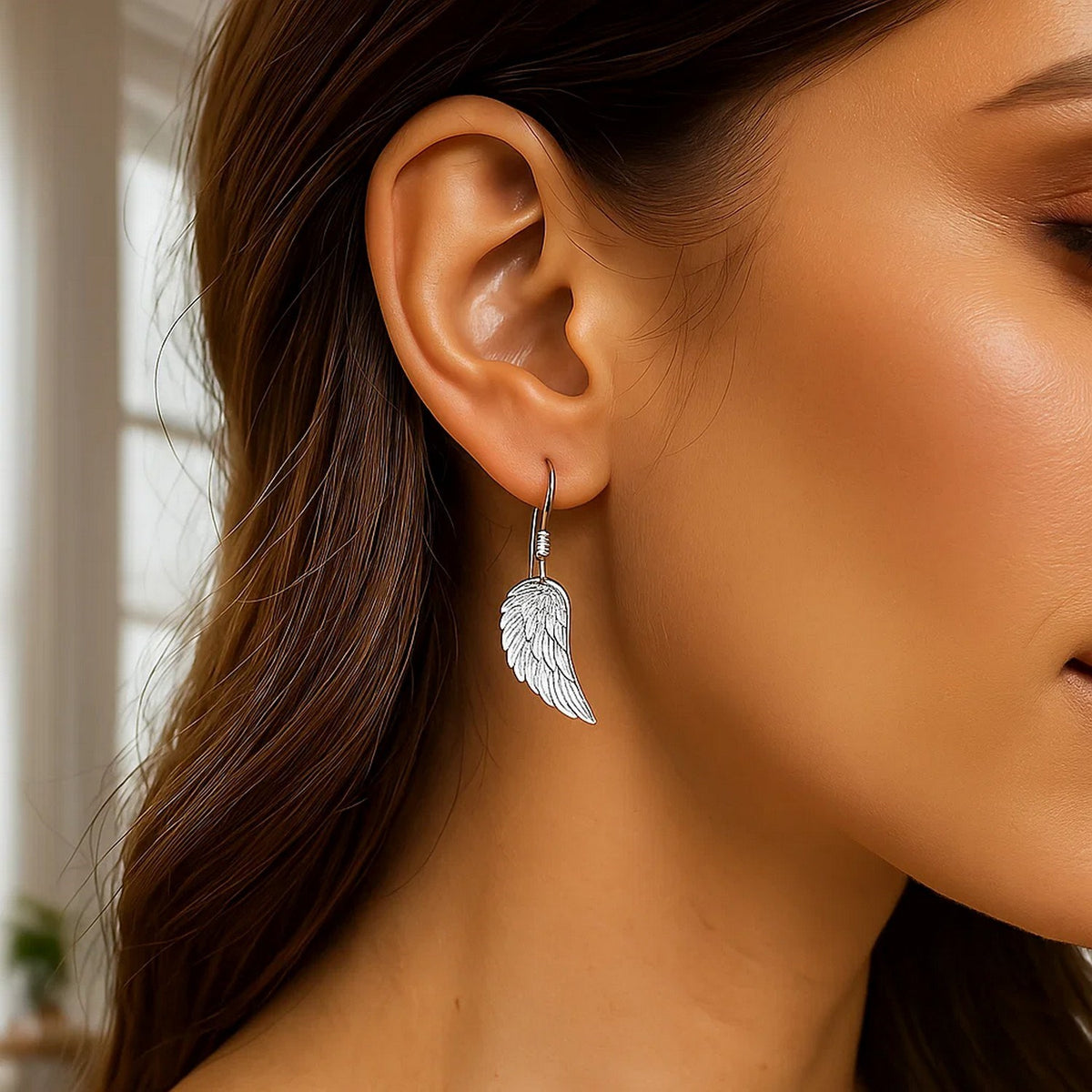 Angel wing earrings in 925 sterling silver with rhodium finish, close-up detail of texture
